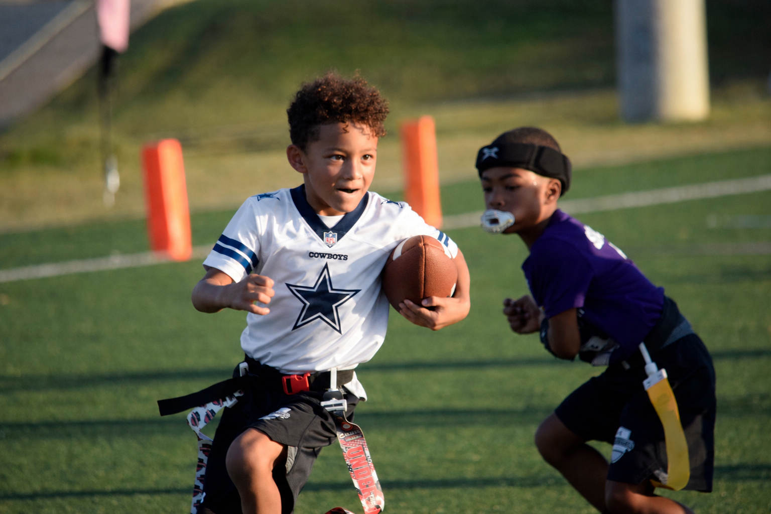 Youth flag football player running with the ball